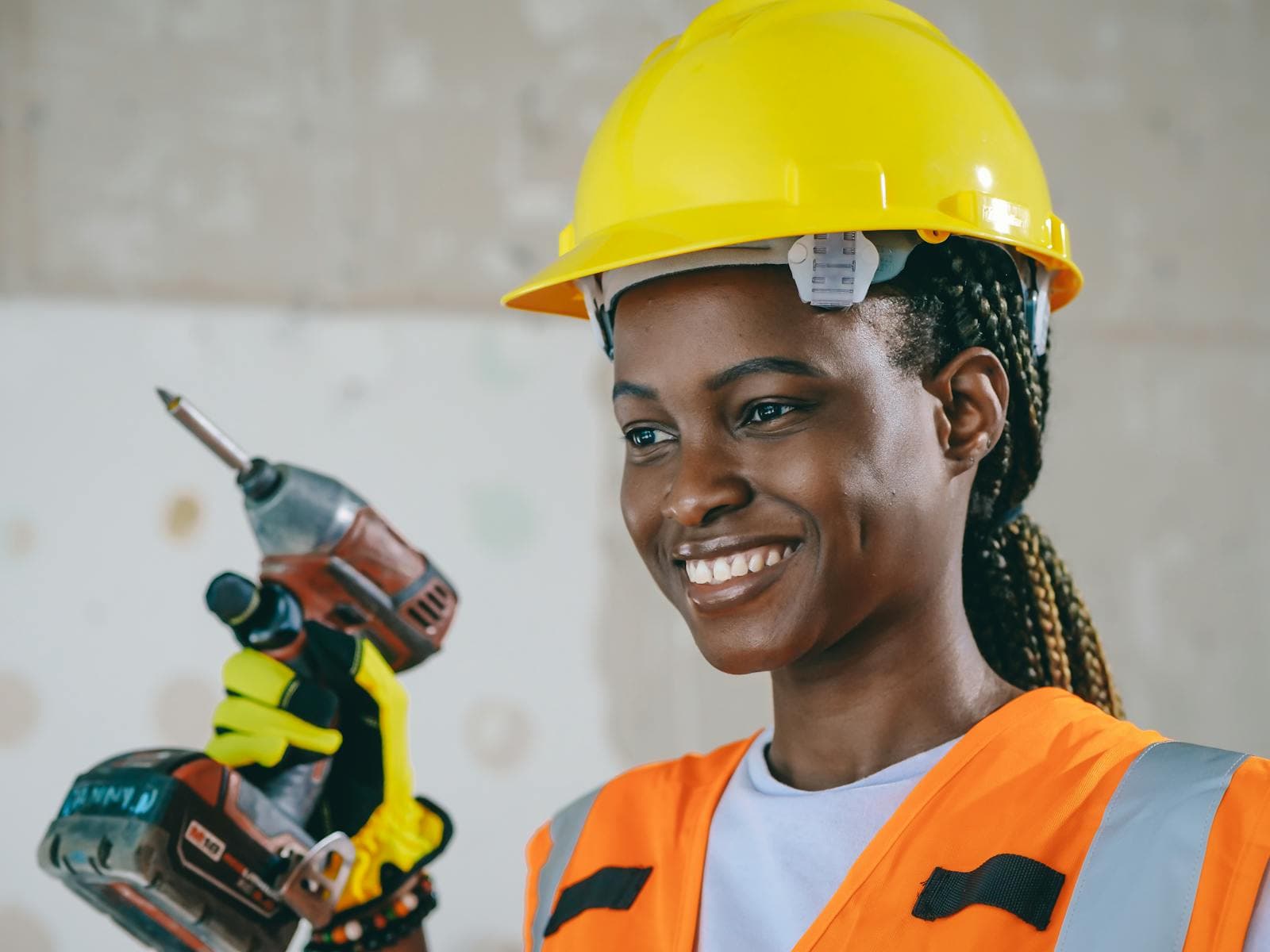 Confident female electrical trainee in safety gear