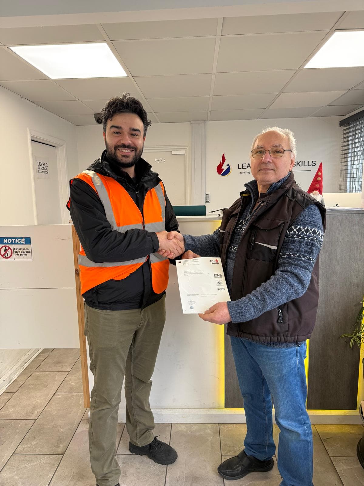 Student in hi-vis vest receiving certificate