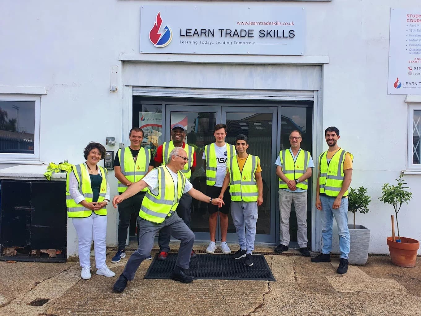 Group of students in hi-vis vests outside Learn Trade Skills
