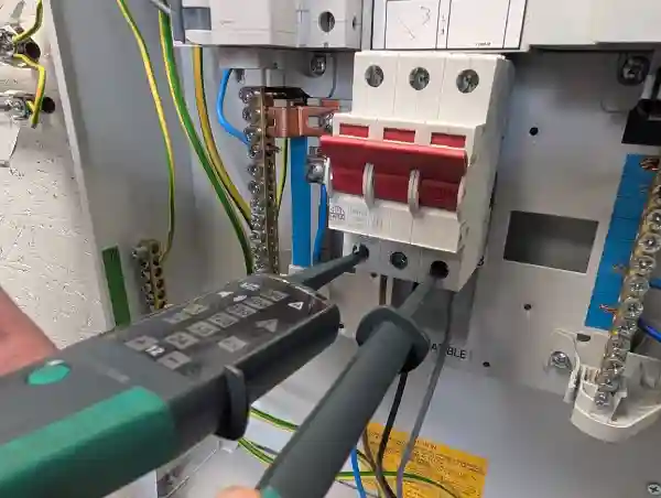 Voltage indicator probes connected between Line 1 (L1) and Line 3 (L3) terminals inside a three-phase distribution board, verifying the absence of voltage as part of the safe isolation testing sequence.