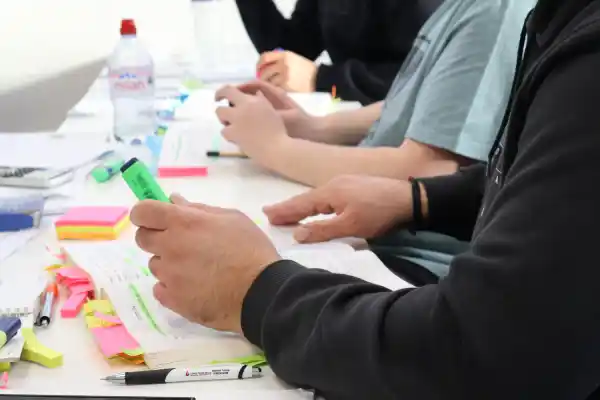 Learners studying on a Fire Alarm Installation Course, highlighting notes with markers during classroom training.